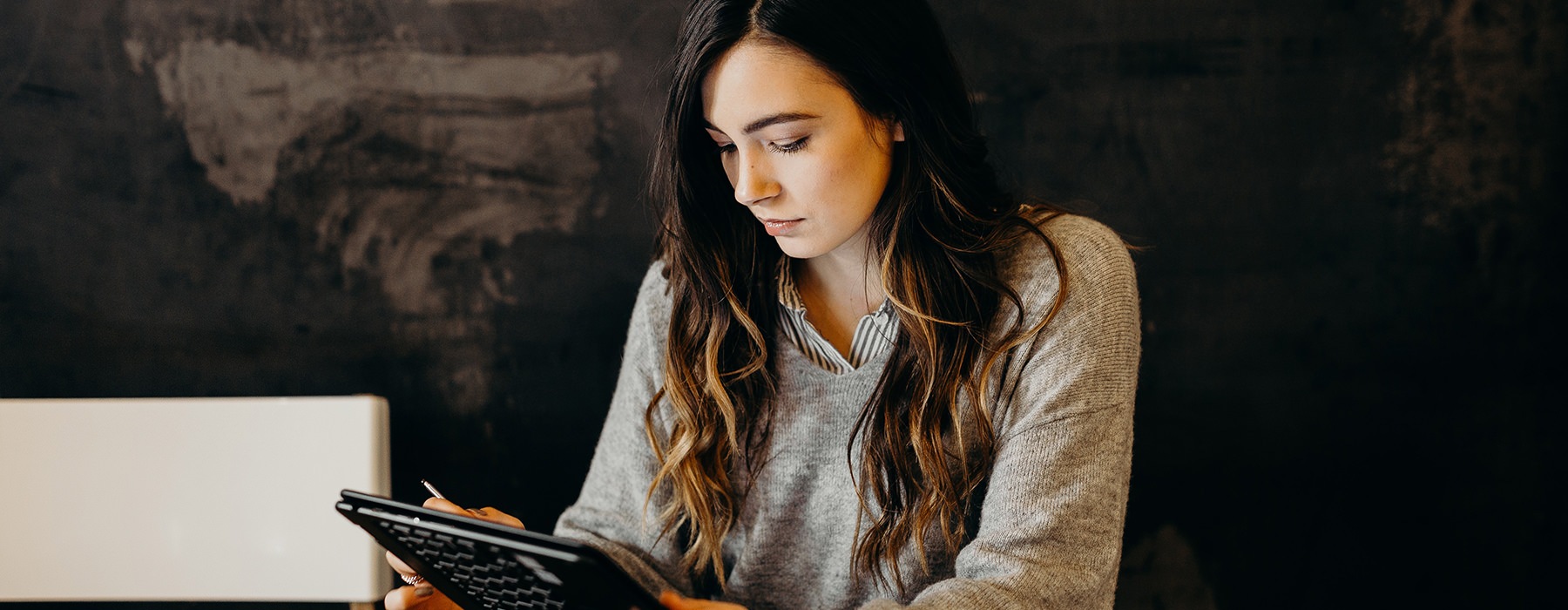 Woman sitting in her room reading her tablet